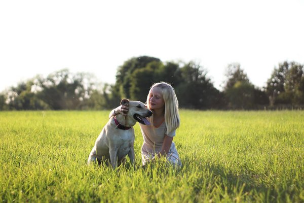 junges Mädchen mit Hund auf Wiese