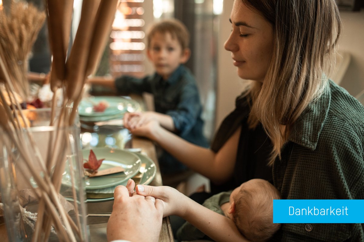 Familien am Tisch sich an den Händen haltend